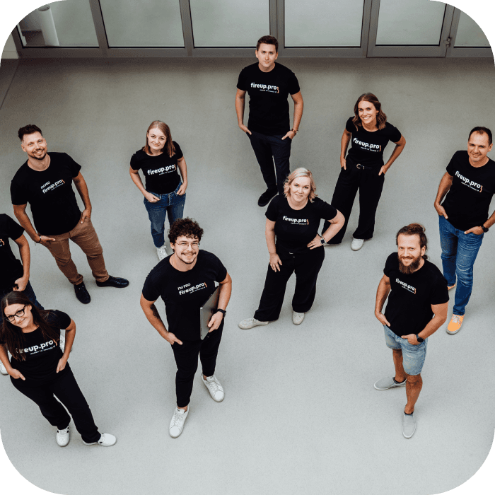 In the photo, members of the software house fireup.pro team are standing in black company t-shirts with the brand's logo. These are the people behind the development services used by clients both in Poland and internationally.