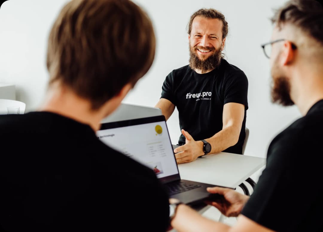 fireup.pro – your front-end development agency. In the photo, you can see three smiling IT specialists, passionate about creating modern and functional user interfaces, paying attention to every detail throughout the software development process.